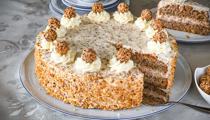 Ein köstliches Giotto Torte Rezept: Eine runde Torte mit Nuss-Crunch, verziert mit Sahnetuffs und Giotto-Kugeln.