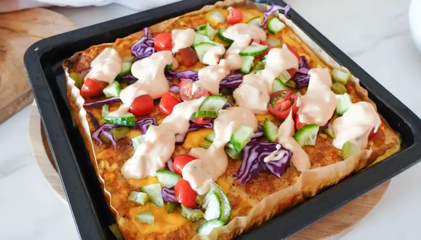 Herzhafte low carb rezepte einfach: Gebackene Tortilla mit Hackfleisch, Käse, Tomaten, Gurken, Rotkohl und Sauce.