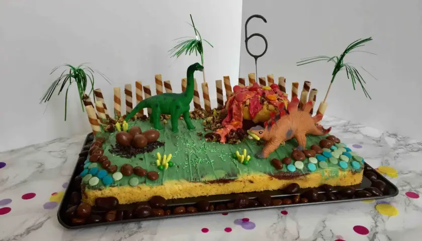 Lustige Kuchen für Kindergeburtstag Jungen: Ein Dino-Abenteuer mit Vulkan, Eiern und Palmen.