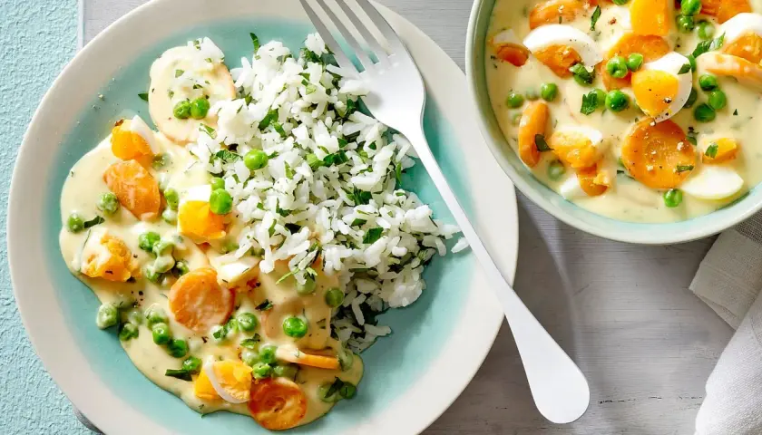 Vegetarische rezepte hauptgericht: Reis mit cremiger Sauce, Erbsen, Karotten und Ei.