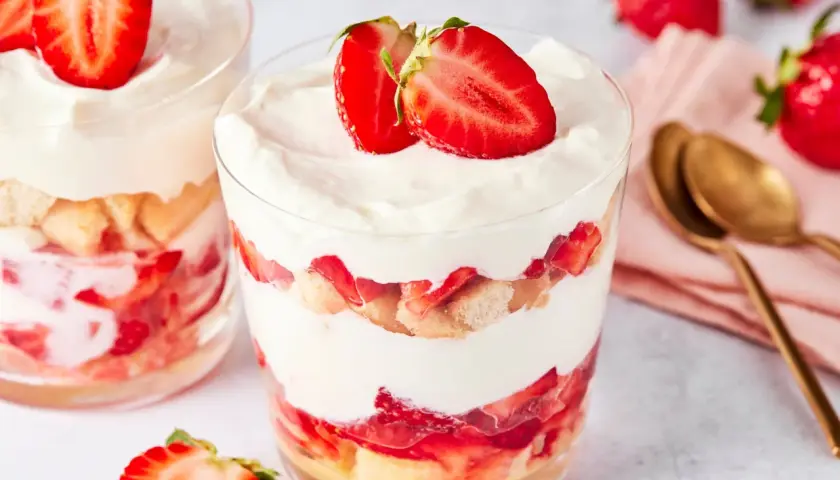 Erdbeer Tiramisu im Glas: Schichten aus Löffelbiskuits, frischen Erdbeeren und cremiger Mascarpone, garniert mit Erdbeerscheiben.