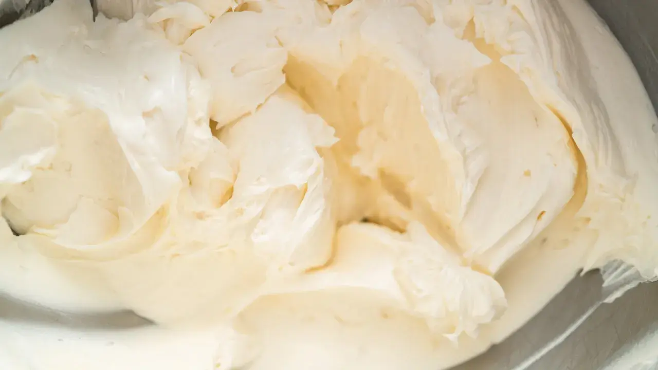 Cremige Buttercreme mit Pudding, die in einer Schüssel aufgeschlagen wird. Die Textur ist glatt und luftig, perfekt für Kuchen und Desserts.
