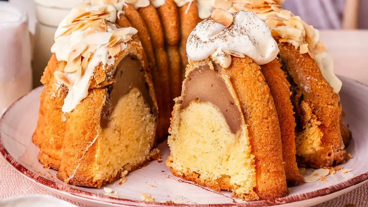 Ein saftiger Gugelhupf mit einer Füllung, verziert mit Sahne und Mandeln. Perfekt für einen sonntagskuchen schnell und einfach.