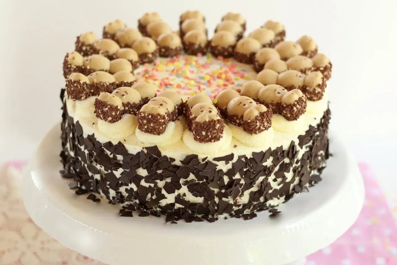 Eine Sahnetorte mit Schokostückchen und süßen Figuren obendrauf. Perfekt für geile Torten Rezepte!