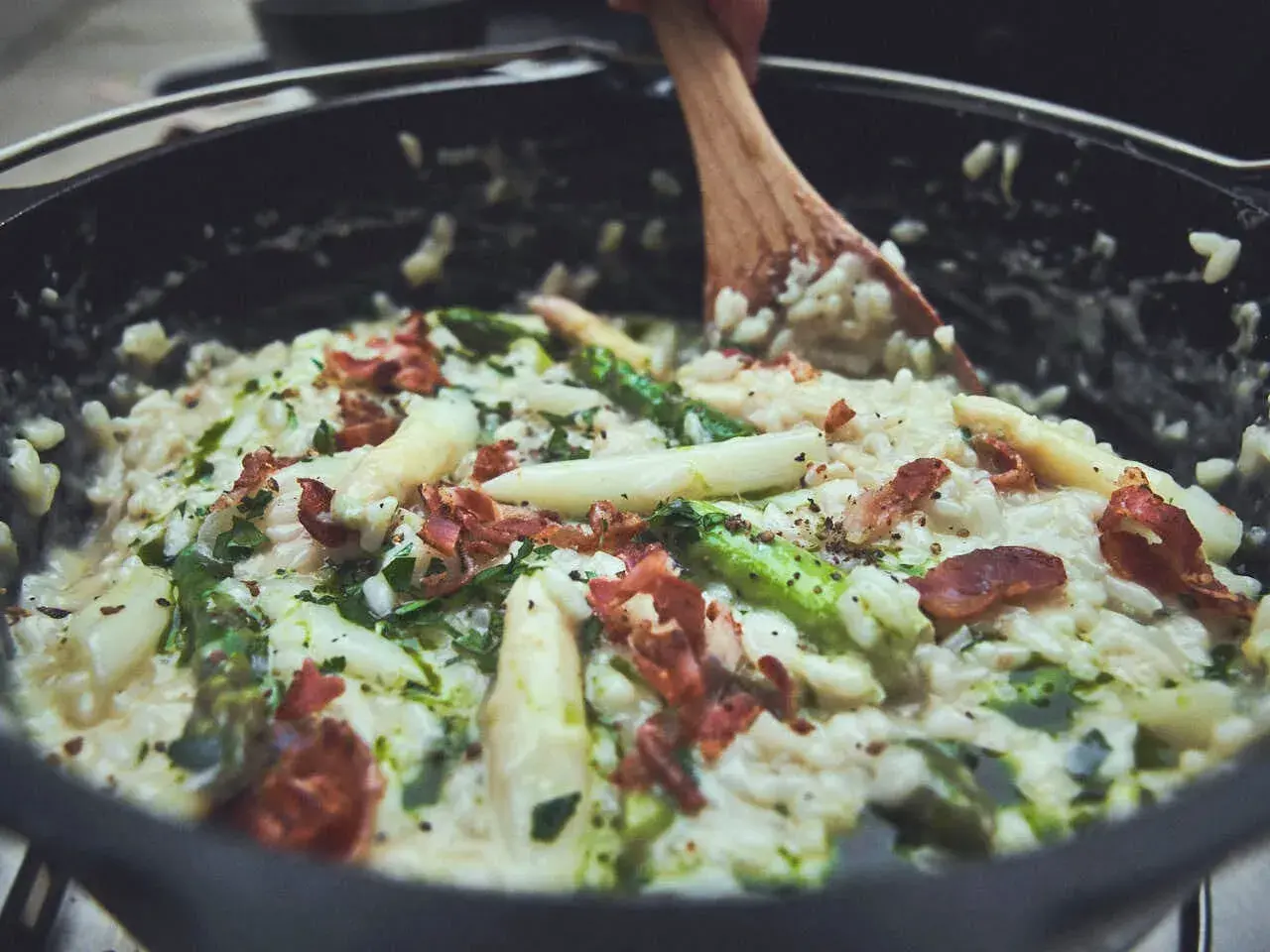 Cremiges Spargelrisotto mit Speck, zubereitet im Dutch Oven. Ein köstliches Gericht, das zeigt, wie vielseitig Dutch Oven Rezepte sind.