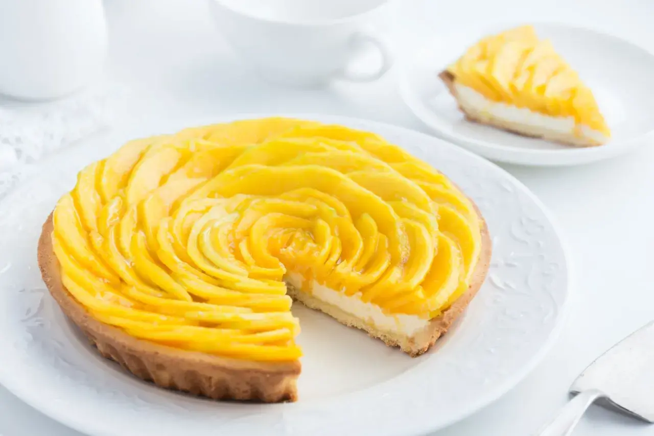 Ein wunderschöner Mango-Tarte, der einen einfachen und raffinierten nachtisch darstellt. Die Mango-Scheiben sind kunstvoll zu einer Rose arrangiert.