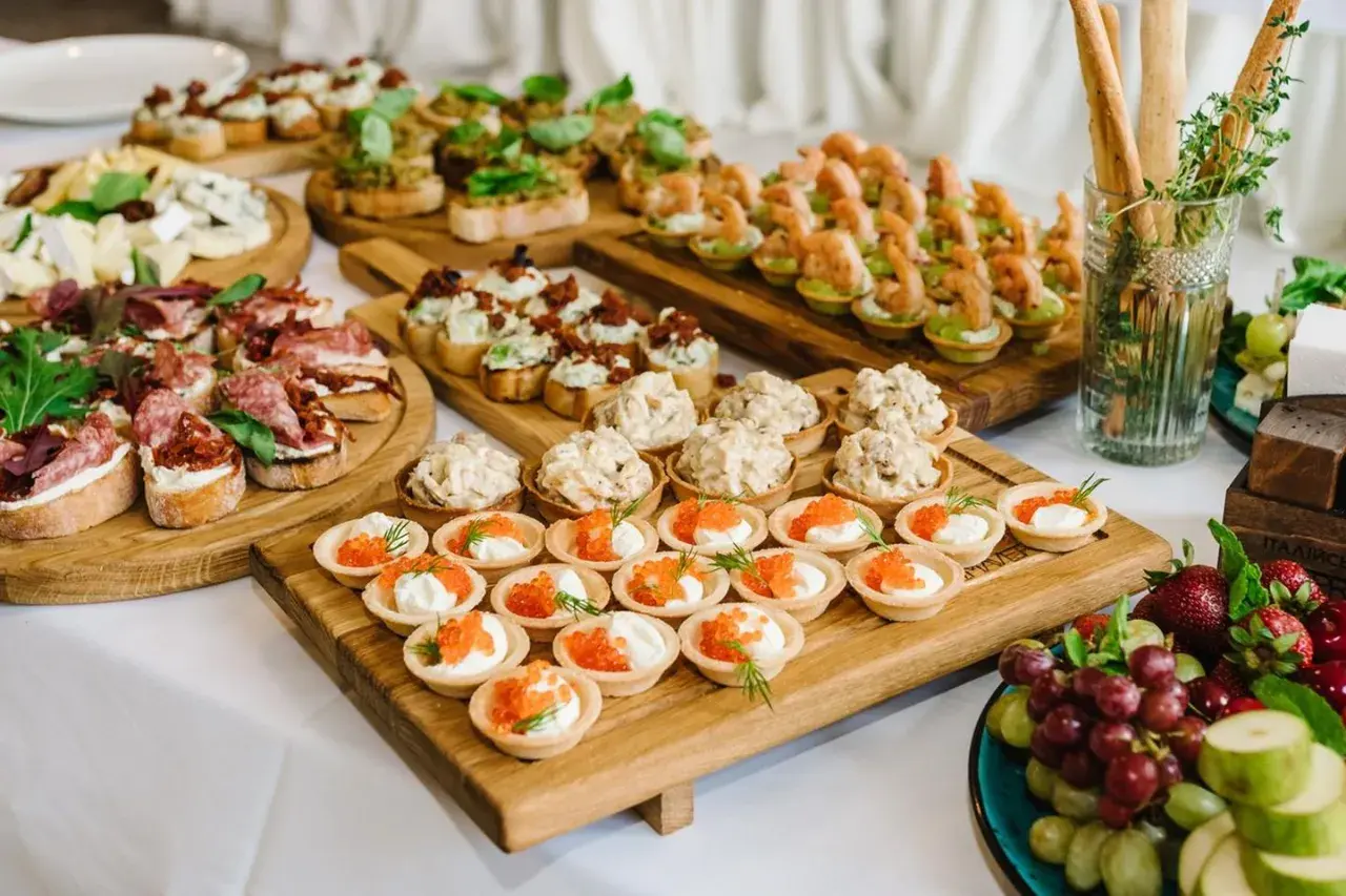 Vielfältige fingerfood ideen: Bruschetta mit Salami, Garnelen-Törtchen, Kaviar-Häppchen und Käseplatte.