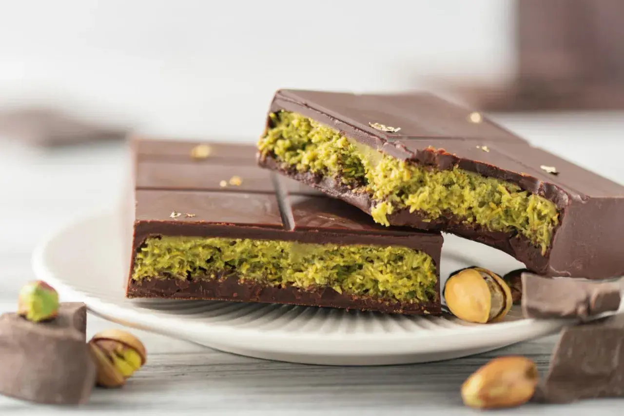 Schokolade mit Pistazienfüllung, inspiriert vom Dubai Schokolade Rezept. Goldene Blättchen zieren die dunkle Schokolade.