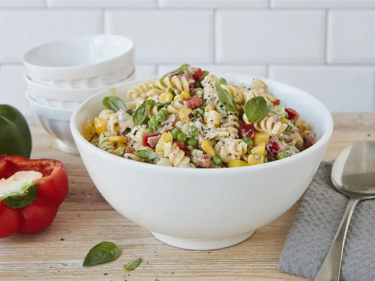 Ein bunter Nudelsalat ohne Mayo, mit Spiralnudeln, Erbsen, Mais, Paprika und frischem Basilikum.