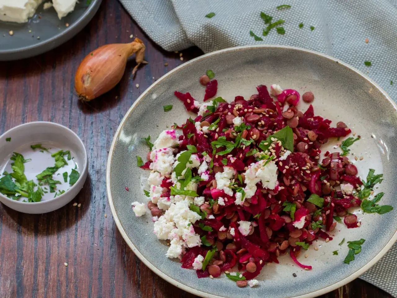 Ein bunter rote Bete Linsen Salat mit Feta und frischer Petersilie, garniert mit Sesam.