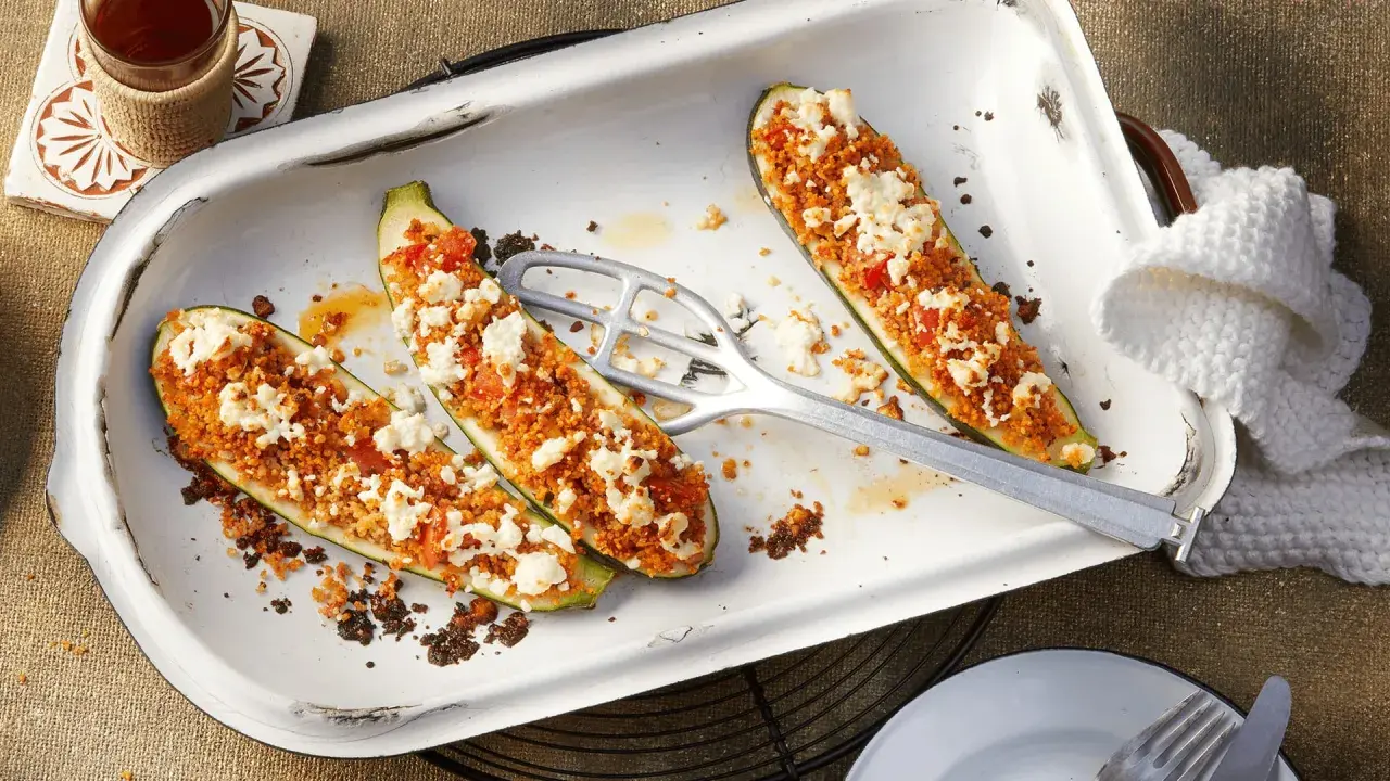 Gefüllte Zucchinihälften mit einer würzigen Couscous-Tomaten-Mischung und zerbröckeltem Feta. Ein raffiniertes vegetarisches Hauptgericht, das Appetit macht.