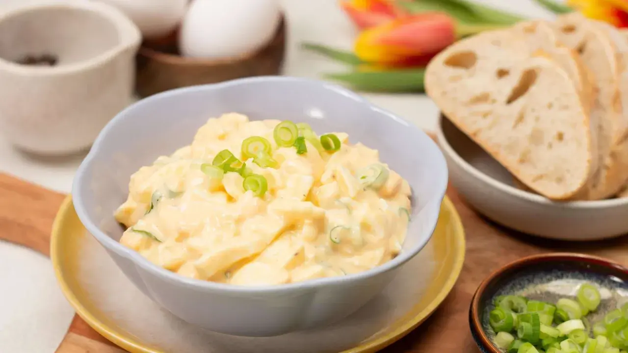 Cremiger eiersalat ohne mayo, garniert mit Frühlingszwiebeln, serviert mit Brot.