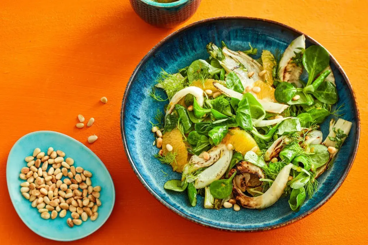 Erfrischender Fenchel-Orangen-Salat mit Pinienkernen, garniert mit Dill.