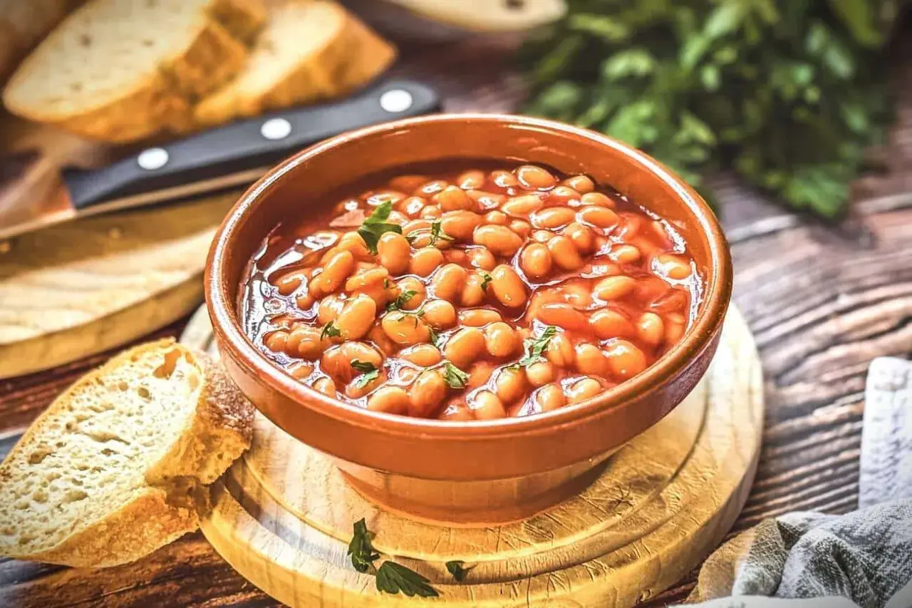 Herzhaftes baked beans rezept in einer Schüssel, garniert mit Petersilie, serviert mit frischem Brot.