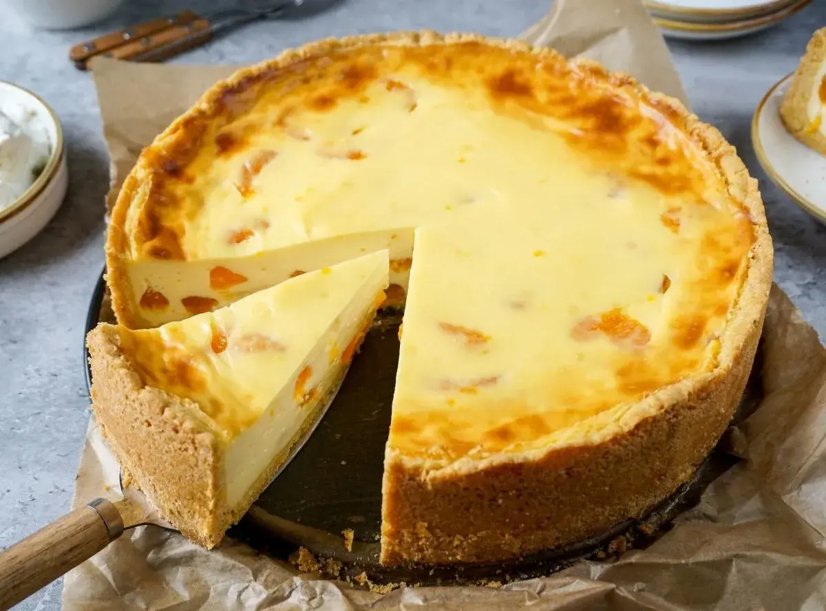Ein saftiger Mandarinen Schmand Kuchen mit einem knusprigen Boden und einer cremigen Füllung, verziert mit saftigen Mandarinenstücken.