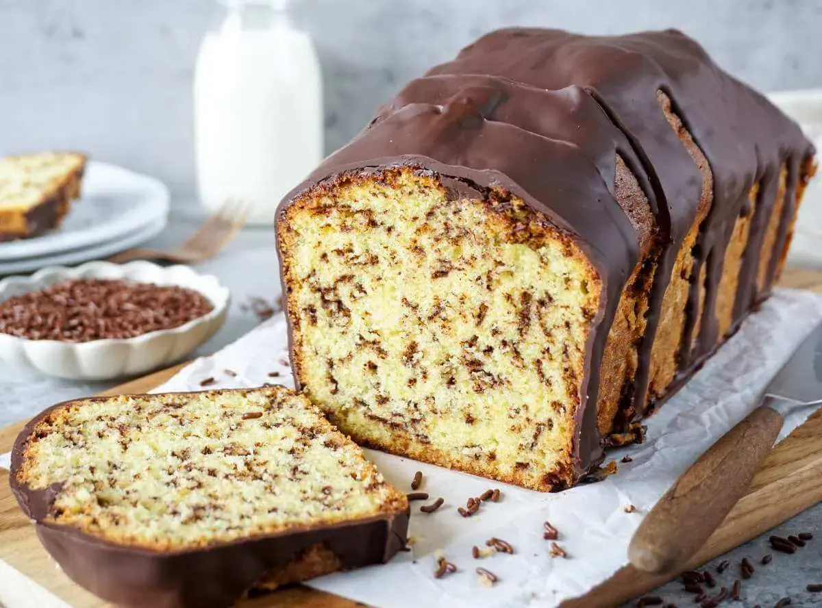 Schokoladenkuchen mit Streuseln, wie aus omas beste kuchen rezepte. Ein Stück ist angeschnitten, daneben eine Schale mit Streuseln.