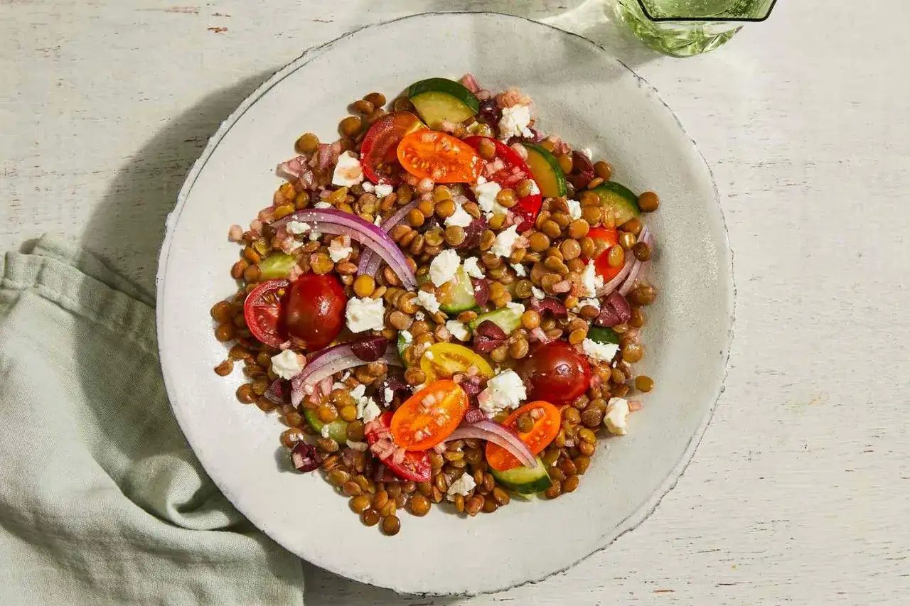 Ein bunter Linsensalat mit Feta, Kirschtomaten, Gurken und roten Zwiebeln.