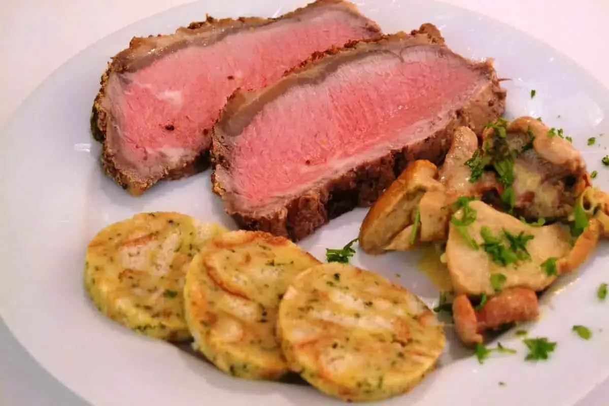 Saftiges Roastbeef im Ofen, perfekt rosa gebraten, serviert mit Klößen und Pilzen. Ein Genuss!