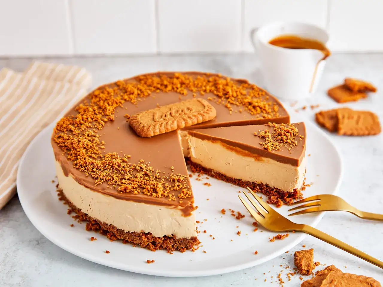 Ein k&ouml;stlicher Lotus Cheesecake mit Karamellglasur und Keksbr&ouml;seln, garniert mit einem Lotus Keks. Perfekt f&uuml;r Kaffeepause.