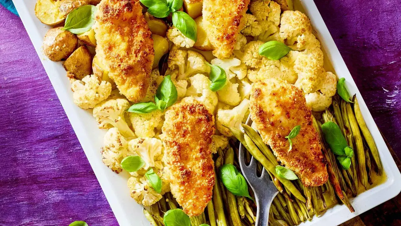 Knusprige H&auml;hnchenbrust mit Blumenkohl, Kartoffeln und gr&uuml;nen Bohnen, garniert mit Basilikum. Perfekt f&uuml;r leckere Rezepte mit Parmesan.