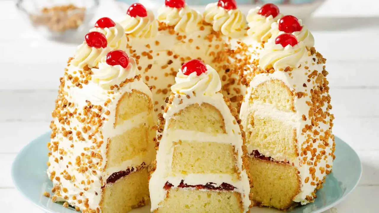 Ein köstlicher Tortenklassiker, der an Omas beste Kuchen Rezepte erinnert. Cremig, mit Nüssen und Kirschen verziert.