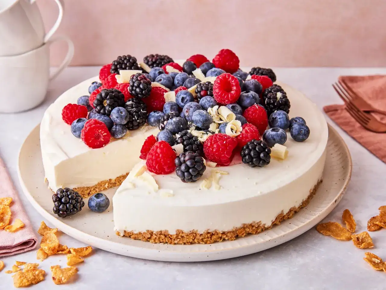Ein köstlicher 10 min kuchen ohne backen, üppig belegt mit frischen Beeren und weißen Schokospänen. Perfekt für schnelle Naschkatzen!