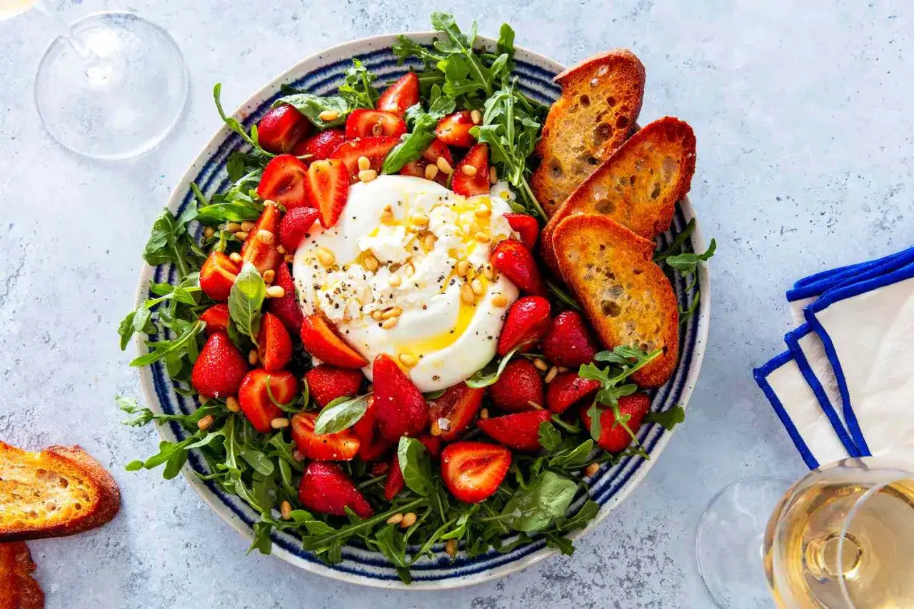 Burrata mit Erdbeeren, Rucola und ger&ouml;stetem Brot &ndash; ein leichtes Gericht, das sich gut f&uuml;r sommerliche Burrata Rezepte eignet.