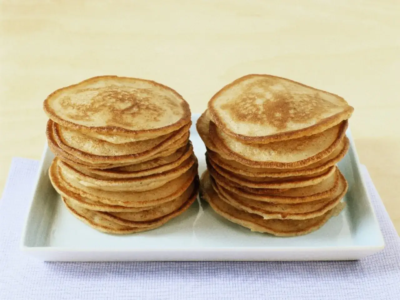 Zwei Stapel goldbrauner Pfannkuchen ohne Ei auf einem wei&szlig;en Teller. Perfekt f&uuml;r ein leichtes Fr&uuml;hst&uuml;ck.