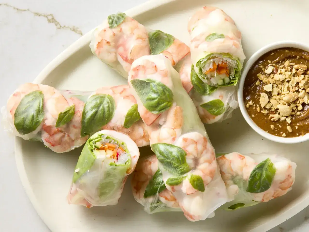 Frische Sommerrollen mit Garnelen, Gem&uuml;se und Basilikum, serviert mit Erdnusssauce. Ein leichtes und gesundes Sommerrollen Rezept.