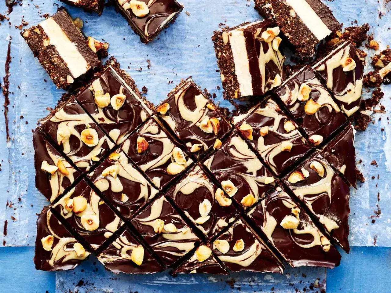 Schokoladen-Nuss-Riegel mit cremiger Füllung, garniert mit Haselnüssen. Perfekt für schnelle Desserts zum Vorbereiten.