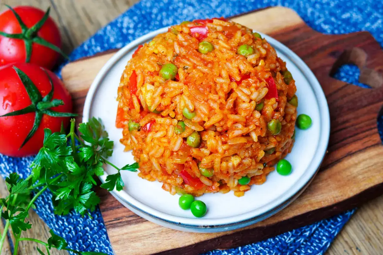 Ein Berg aus würzigem Djuvec Reis mit Erbsen und Paprika, garniert mit frischer Petersilie und Tomaten.