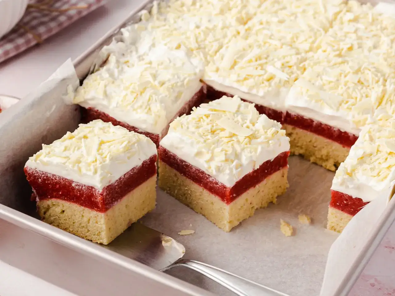 Schichtkuchen mit roter Fruchtschicht, weißer Creme und Schokostreuseln, wie von Frau Holle gebacken.