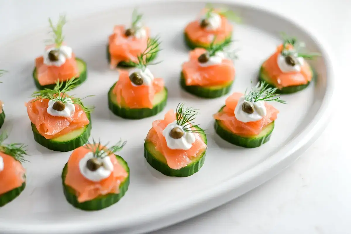 Kleine, appetitliche Vorspeise mit Lachs auf Gurkenscheiben, garniert mit Dill und Kapern.