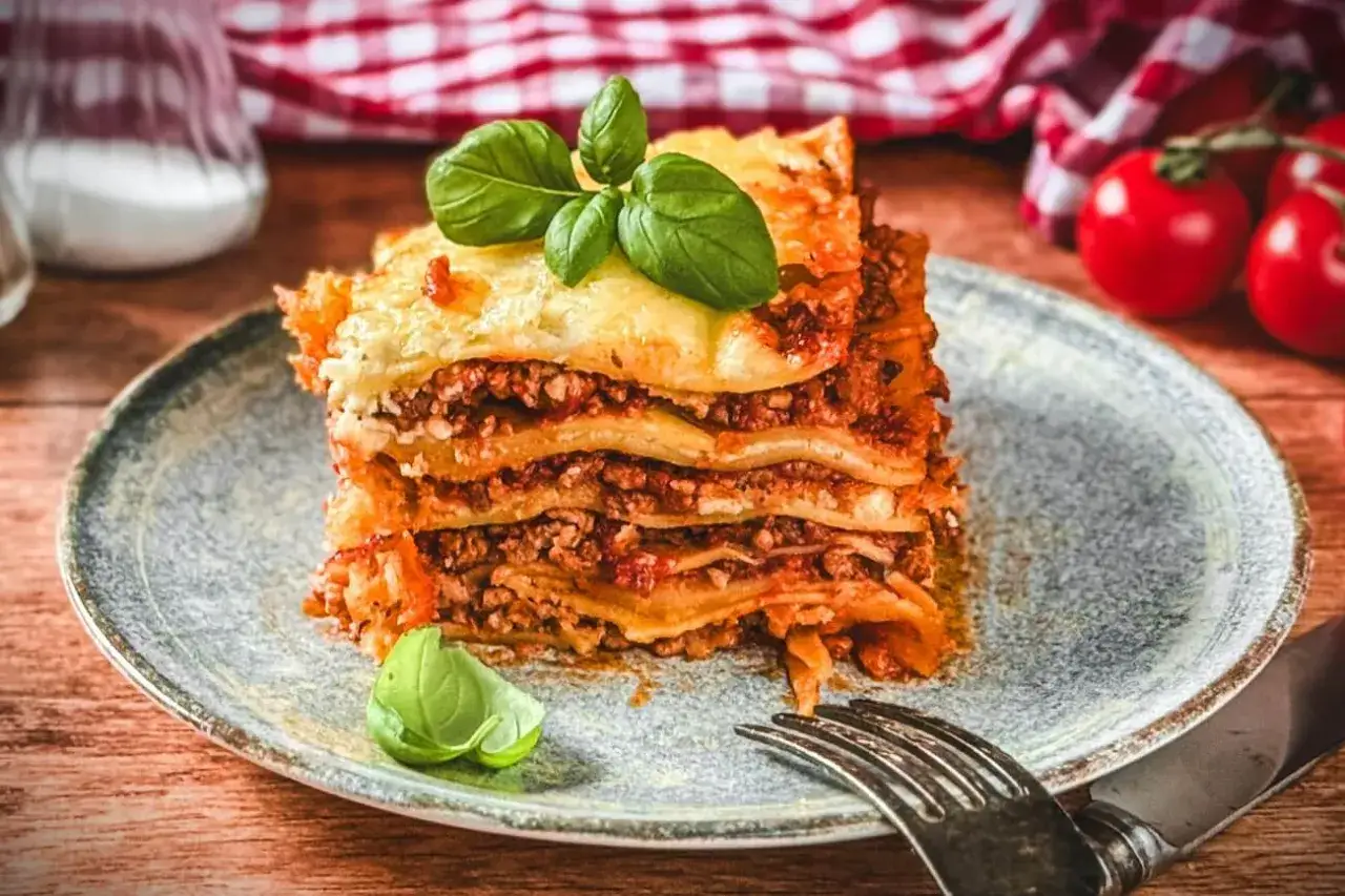 Ein saftiges Stück Lasagne mit Hackfleisch und Käse, garniert mit Basilikum. Perfekt für ein gemütliches Abendessen nach diesem Lasagne Rezept.