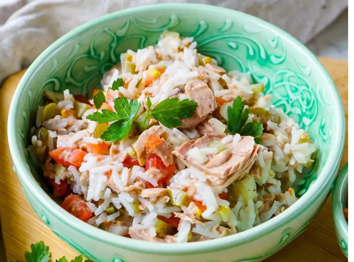 Sch&uuml;ssel mit leckerem Reissalat mit Thunfisch, Tomaten, Gurken und Petersilie.