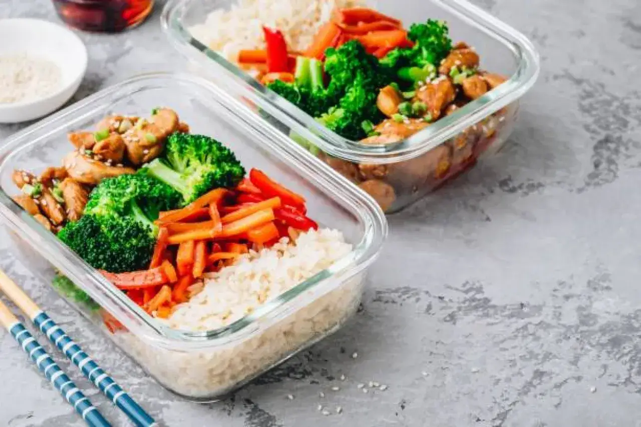 Gesunde meal prep rezepte abnehmen: Hähnchen mit Brokkoli, Karotten und Reis in Glasbehältern. Perfekt für unterwegs.