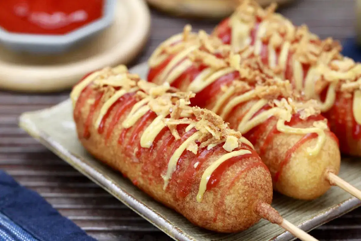 Leckere Corn Dogs mit Ketchup, Senf und knusprigen Zwiebeln. Ein tolles Rezept f&uuml;r Corn Dogs, das jedem schmeckt!